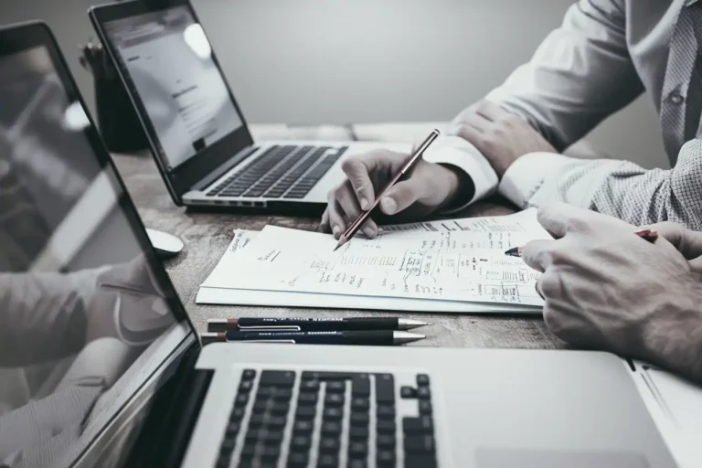 Professionnels collaborant sur des schémas et données, symbolisant la planification et la gestion des compétences.